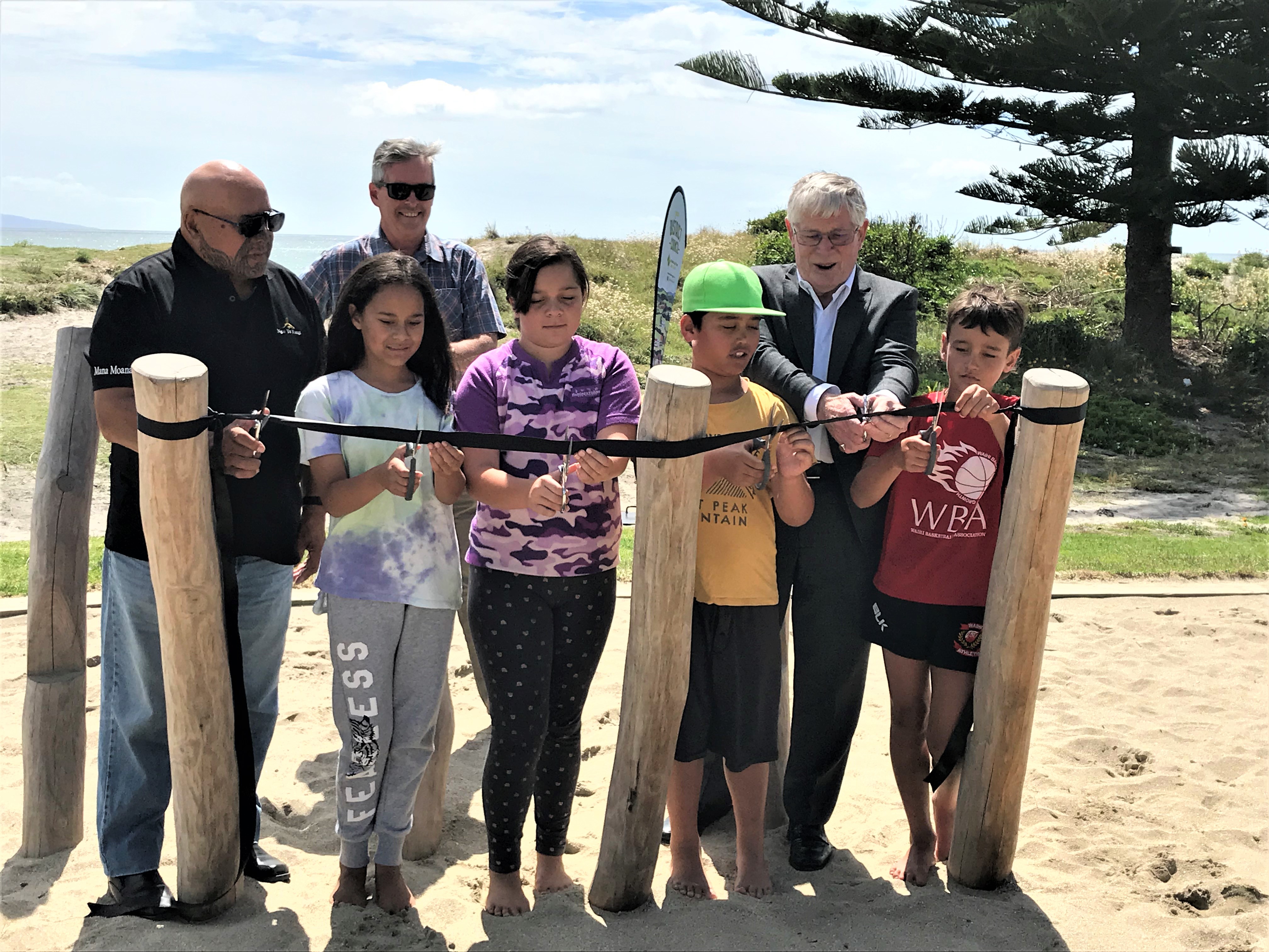  Western Bay Mayor Garry Webber cuts the ribbon for the new Albacore playground with Council’s Reserves and Facilities Manager Peter Watson, Kaumatua Roger Tuanau of Te Whanau a Tauwhao hapū and pupils of Waihi Beach Primary School.