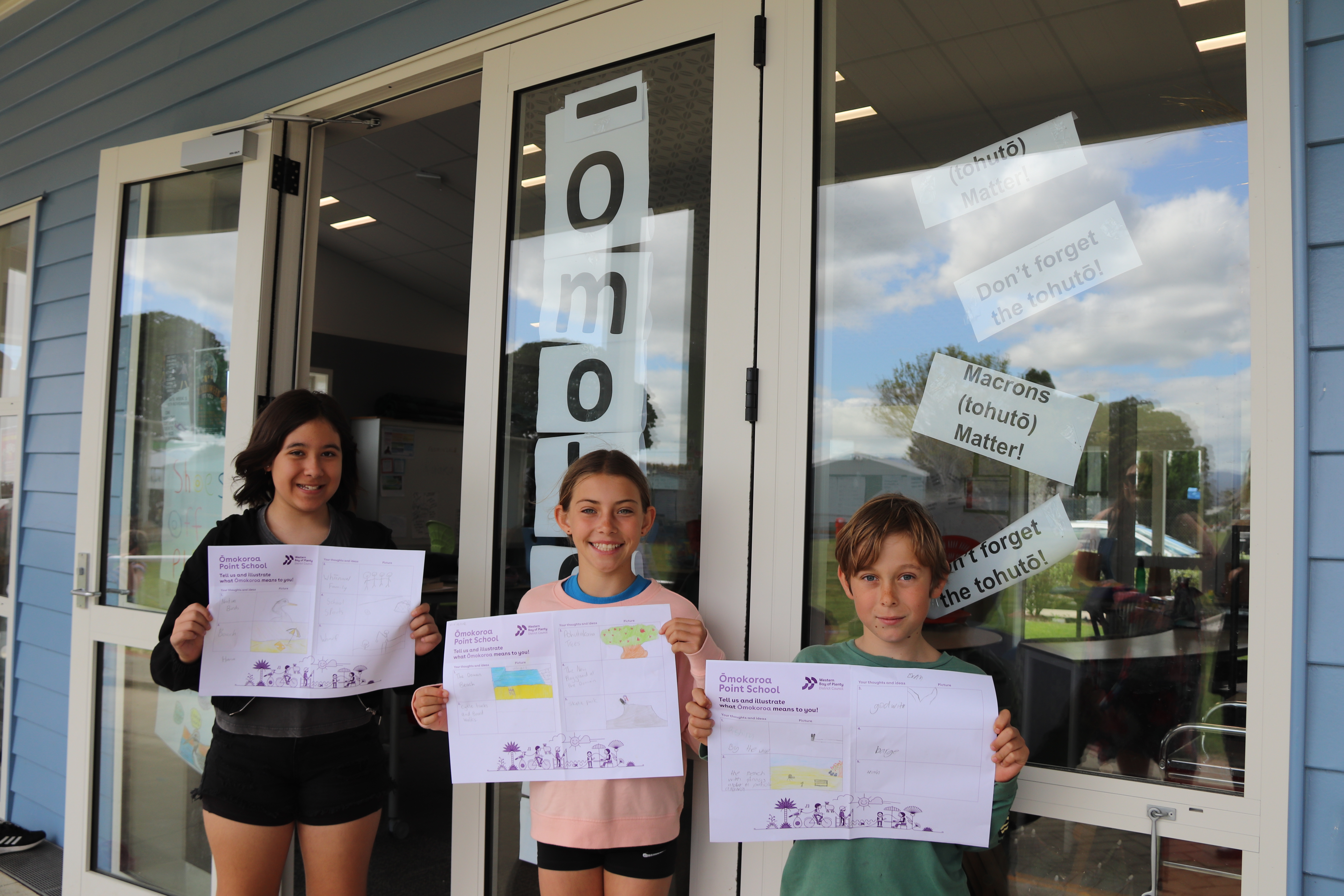 Hana, Vivienne and Evan holding up their designs.