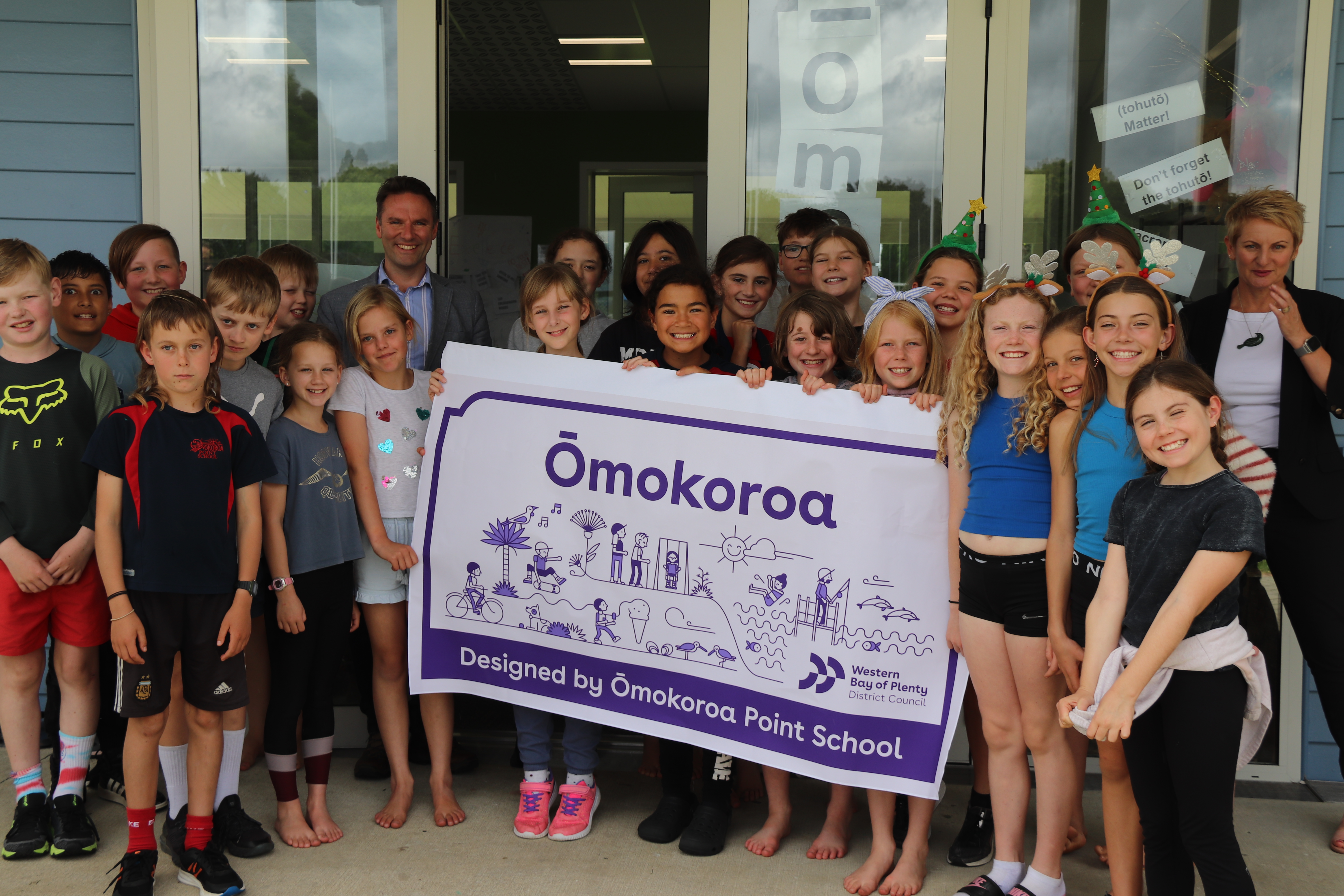 Mayor James Denyer and Ōmokoroa Point School’s Room 10 with the new billboard design.